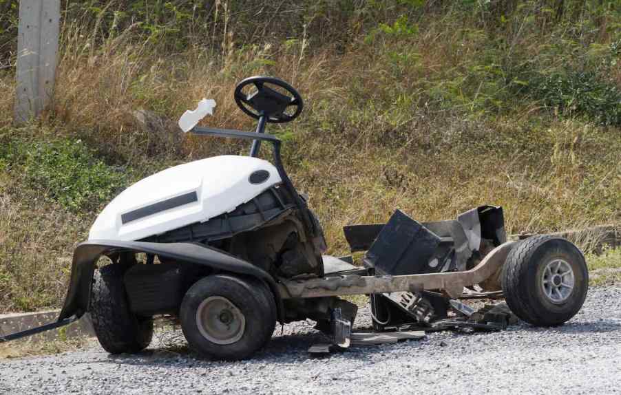 The wreckage of a crashed and bent golf cart.