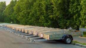 Row of rental trailers in a parking lot, trees visible in the background.