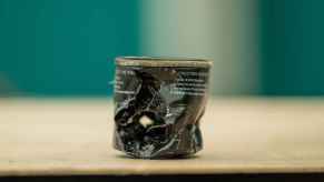 Damaged engine oil filter sitting on a flat surface