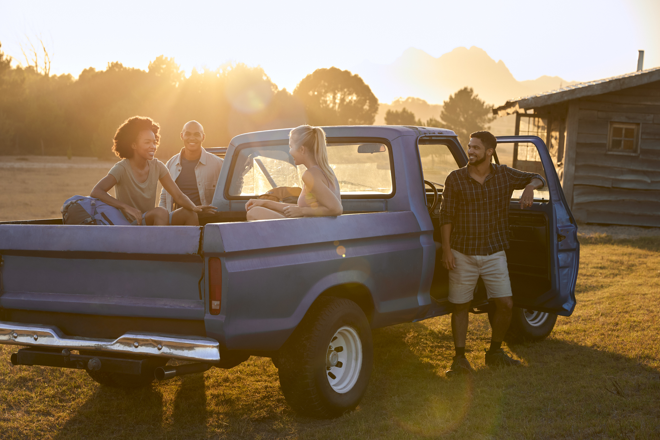 People riding in the back of a truck in field