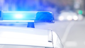 A blue police car light illuminated in close view during the daytime