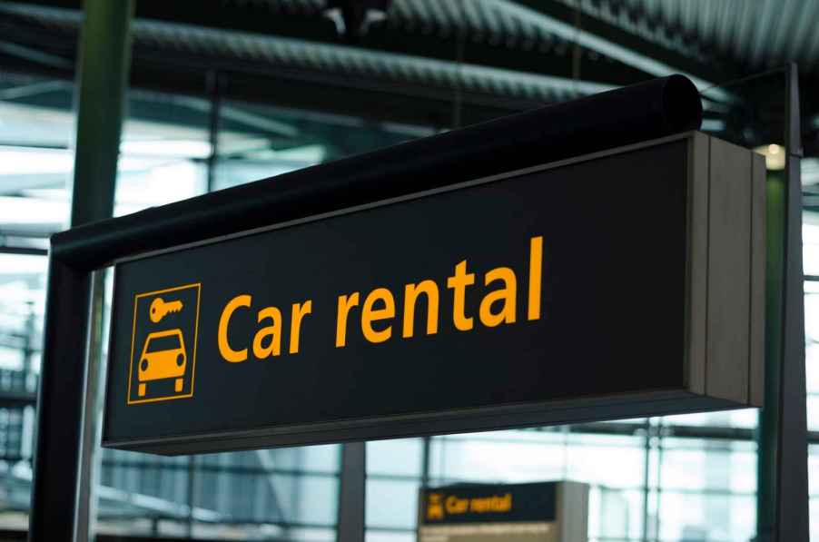 Rental car sign handing from the wall at an airport in close view