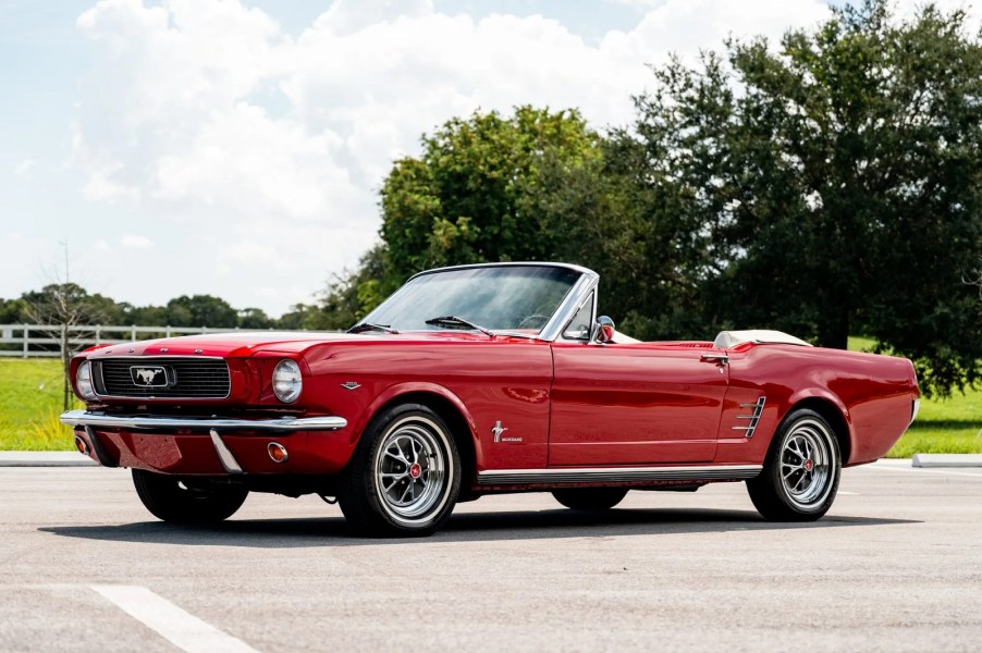 A red 1966 Ford Mustang convertible parked in left side angle view