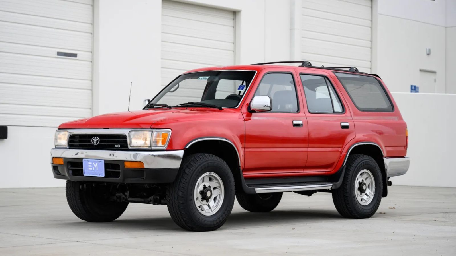 An orange-red 1995 Toyota 4Runner parked in left front angle view