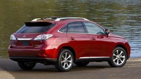A red 2010 Lexus RX 350 SUV parked in front of water in right ear angle view