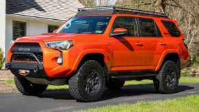 A bright orange 2015 Toyota 4Runner parked in left front angle view