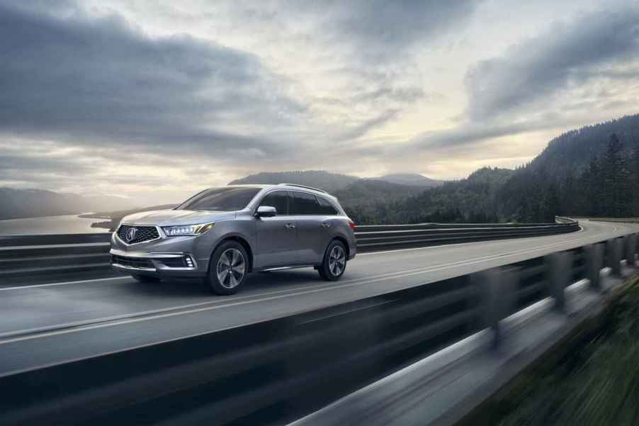 A grey 2017 Acura MDX driving in overcast weather