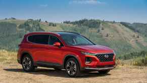 A red 2019 Hyundai Santa Fe parked on a mountain in right front angle view