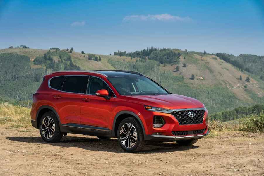 A red 2019 Hyundai Santa Fe parked on a mountain in right front angle view