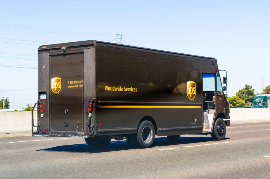 A UPS driver in a box truck on a delivery.