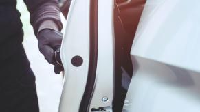 A thief steals a car in broad daylight.