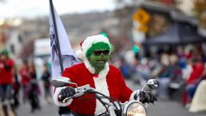 The Grinch on a motorcycle at a parade.
