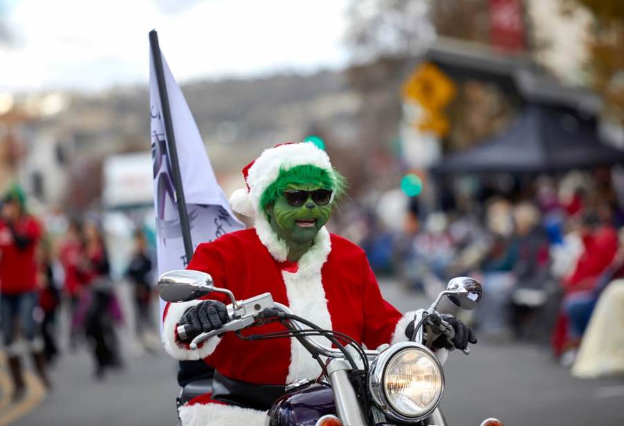 The Grinch on a motorcycle at a parade.