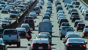 A motorcycle lane-splitting in dense California traffic.