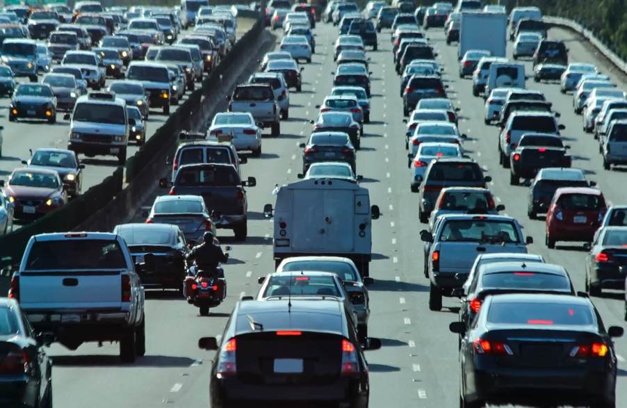 A motorcycle lane-splitting in dense California traffic.