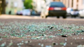 Broken glass in front of a building after a car crash.