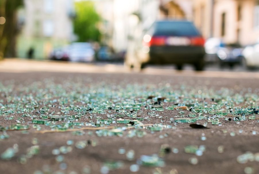 Broken glass in front of a building after a car crash.