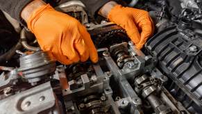 Mechanics working on a car with the top end off.