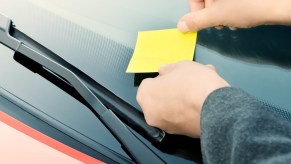 Driver leaving a note on a car after a hit-and-run accident
