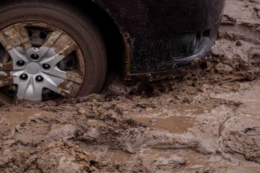 Tires of a pickup truck in a muddy manure pit