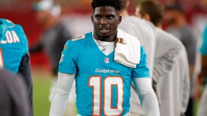 Miami Dolphin's football player Tyreek Hill stands on the field in his jersey after a game.