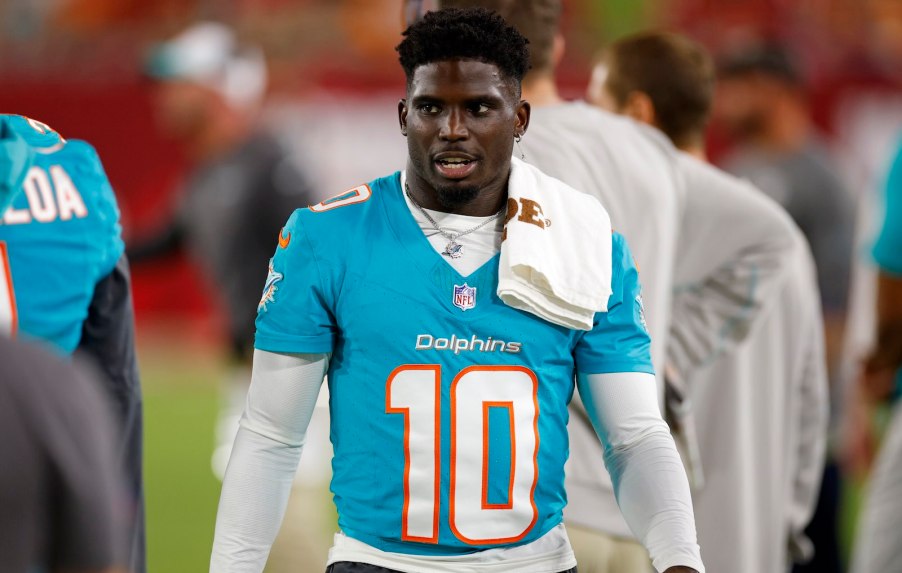 Miami Dolphin's football player Tyreek Hill stands on the field in his jersey after a game.