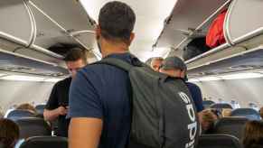 Airplane passengers deboarding standing in aisle