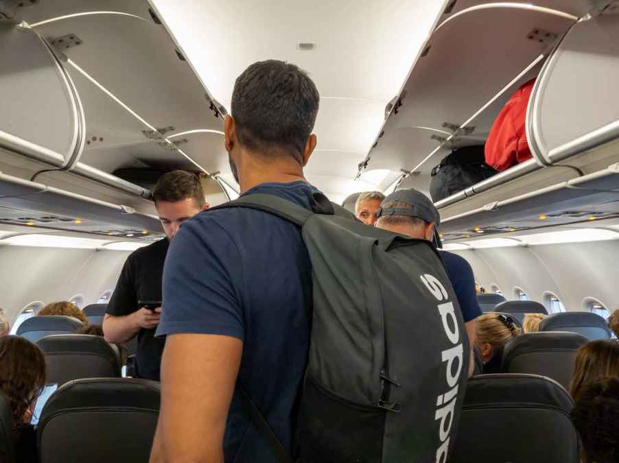 Airplane passengers deboarding standing in aisle