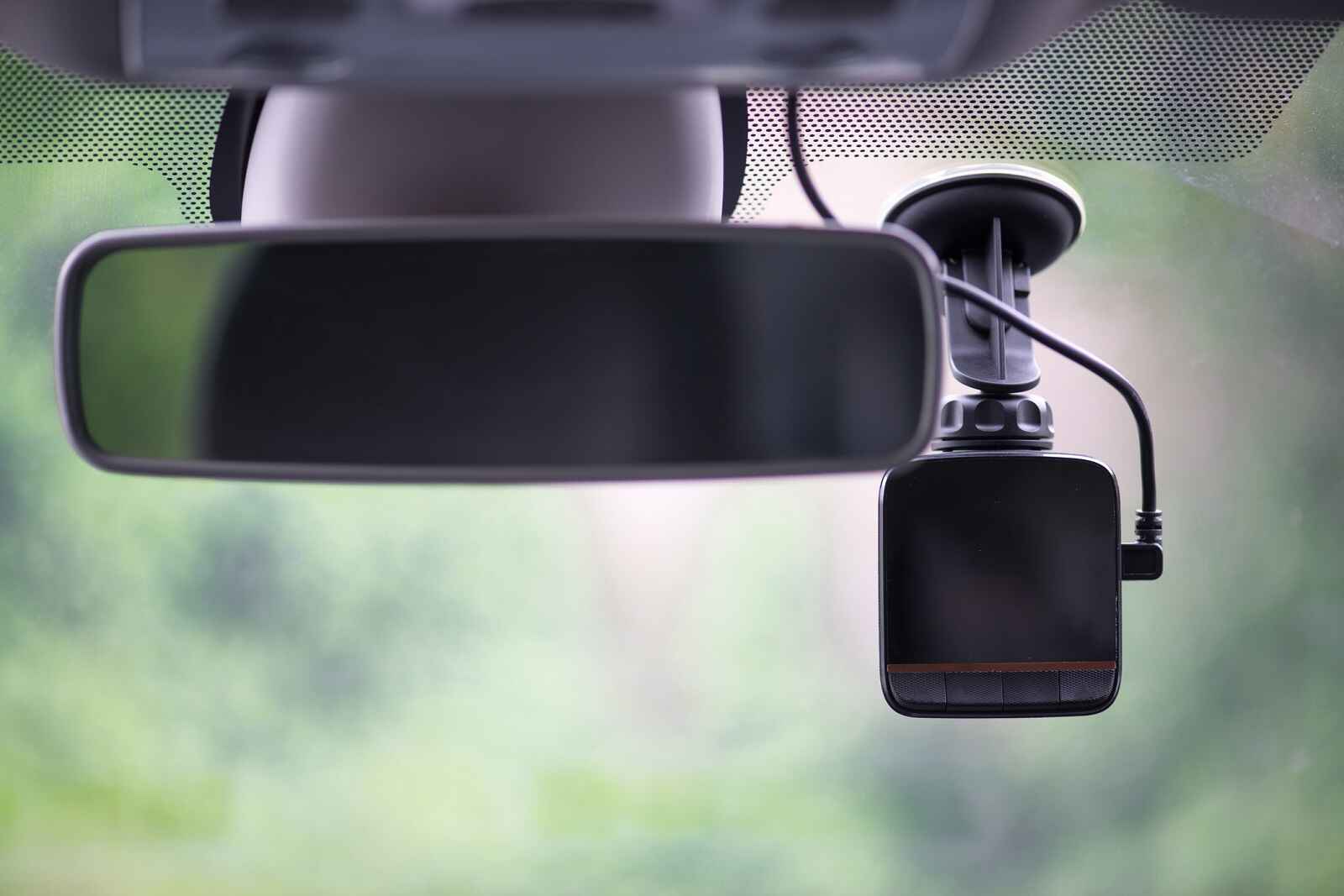 A dash cam mounted inside a vehicle windshield in close view
