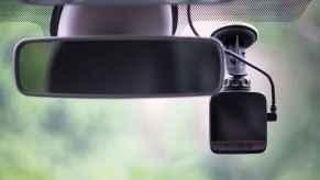 A dash cam mounted inside a vehicle windshield in close view