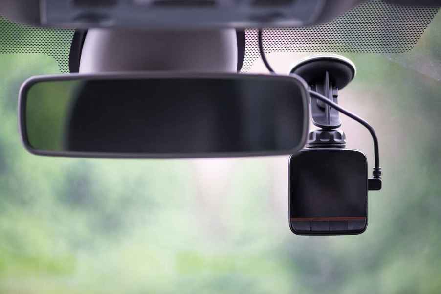 A dash cam mounted inside a vehicle windshield in close view