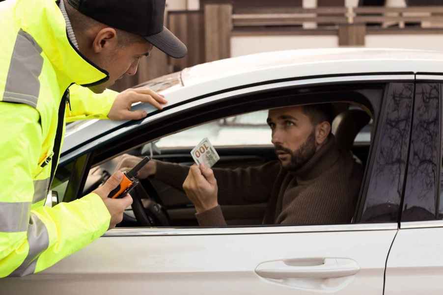 Depiction of driver bribing a police officer