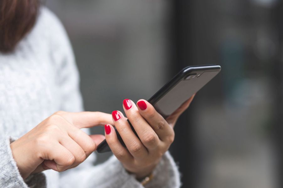 A woman reading a text message on her smartphone