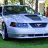 A silver 2001 Ford Mustang GT sitting on a lawn at a car show