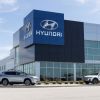The exterior of a Hyundai dealership, with three cars sitting outside of the building