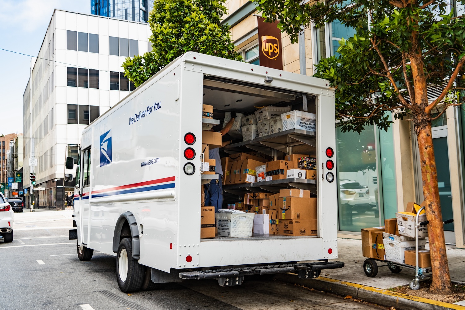 A USPS mail truck filled with packages