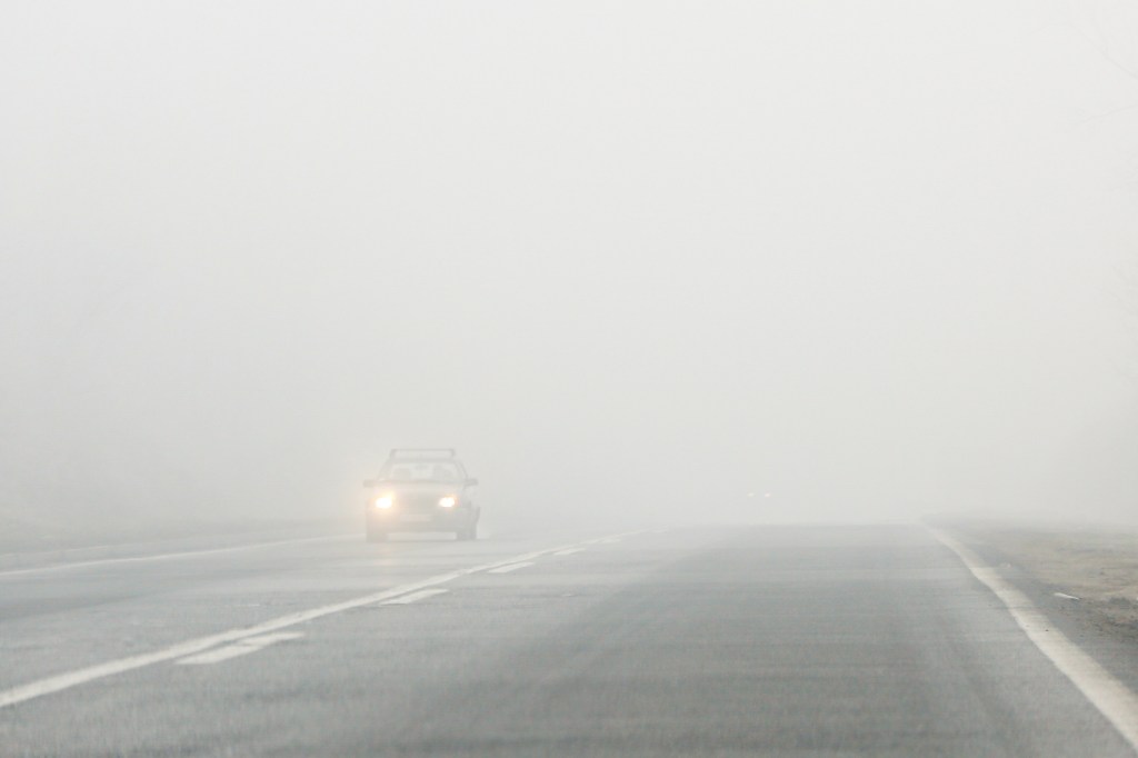 An SUV on the highway in foggy conditions