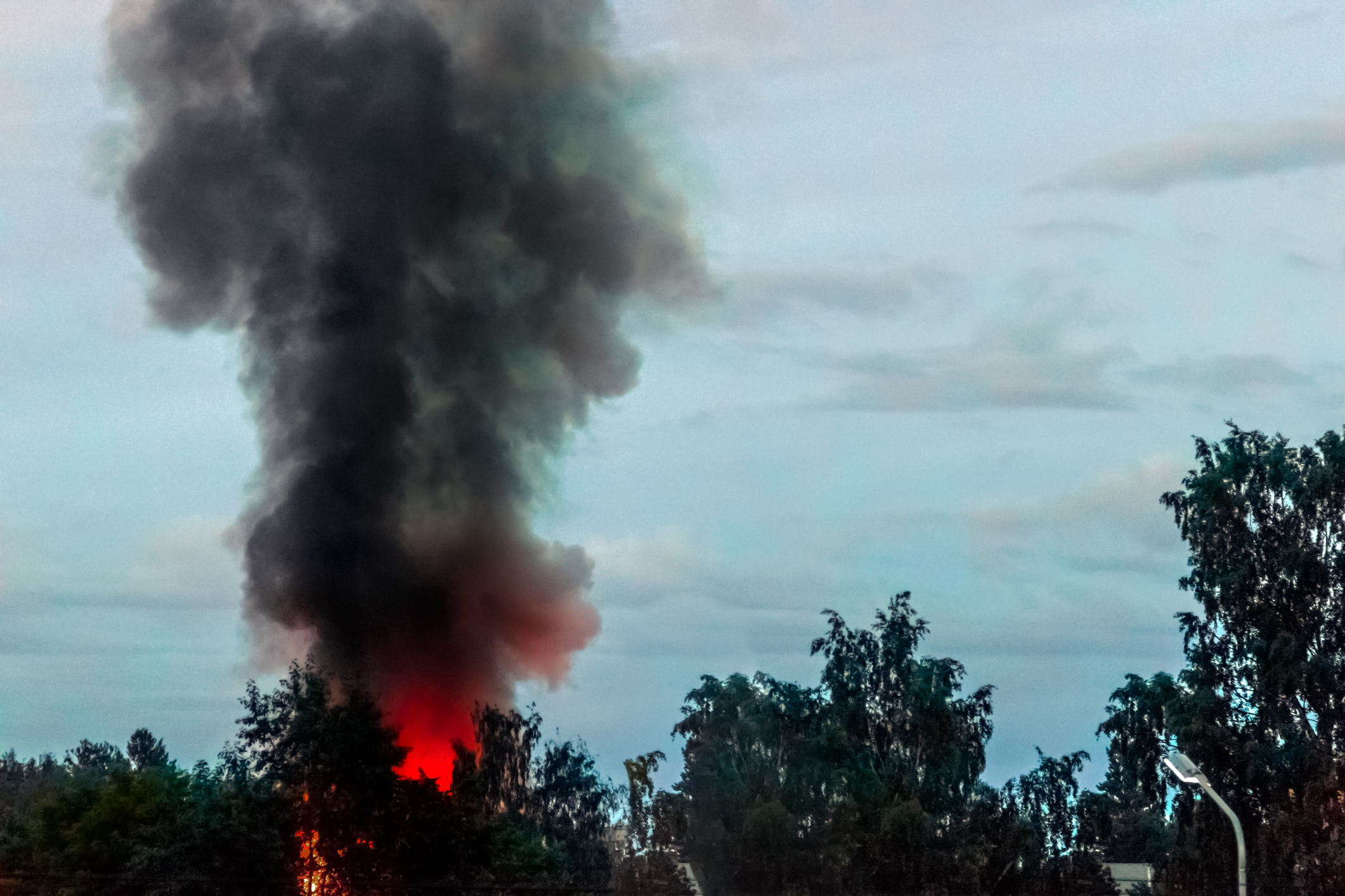 A plume of black smoke rising from a fire 
