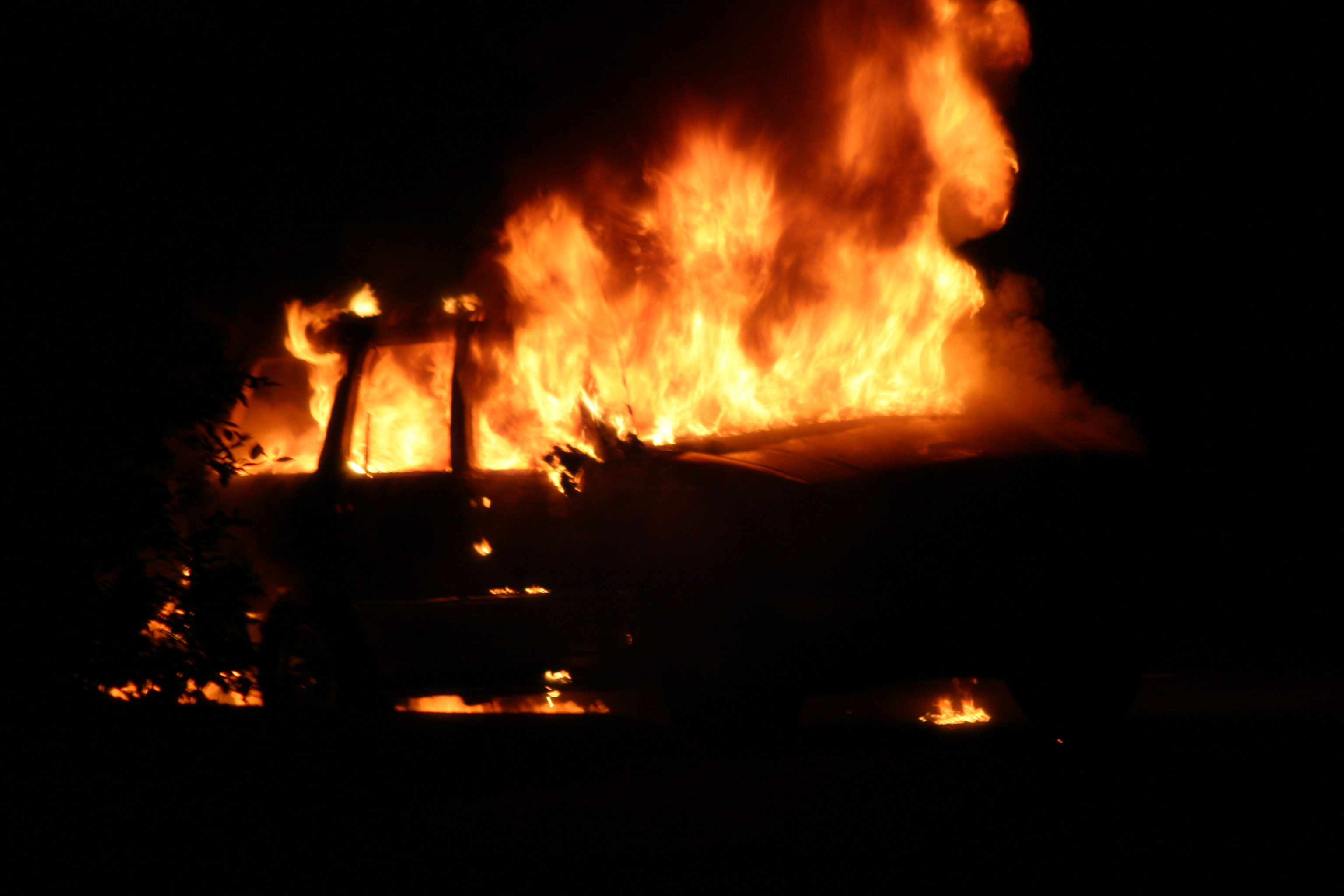 A SUV on fire at night 