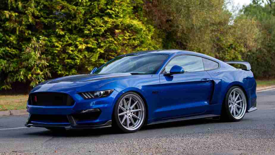 A blue 2017 Ford Mustang GT posed for pictures in an empty parking lot