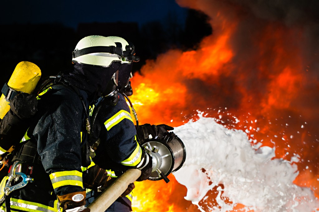 A firefighter spraying water to put out a fire