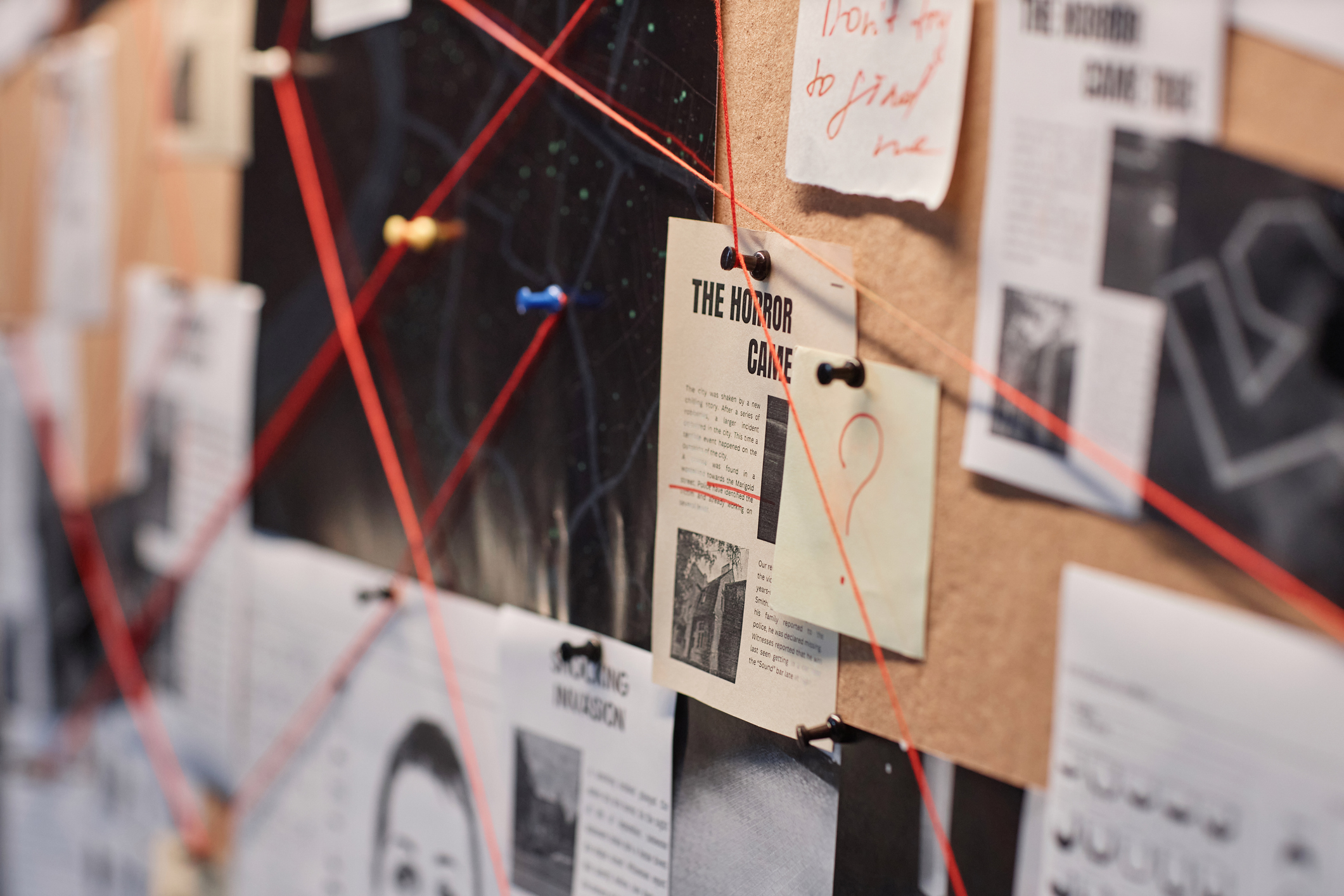 An evidence board with red string 