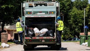 Two man and a garbage truck collecting trash