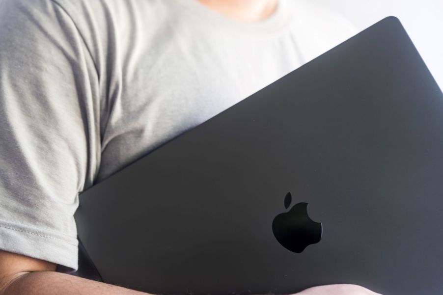 A man holding a Macbook Pro