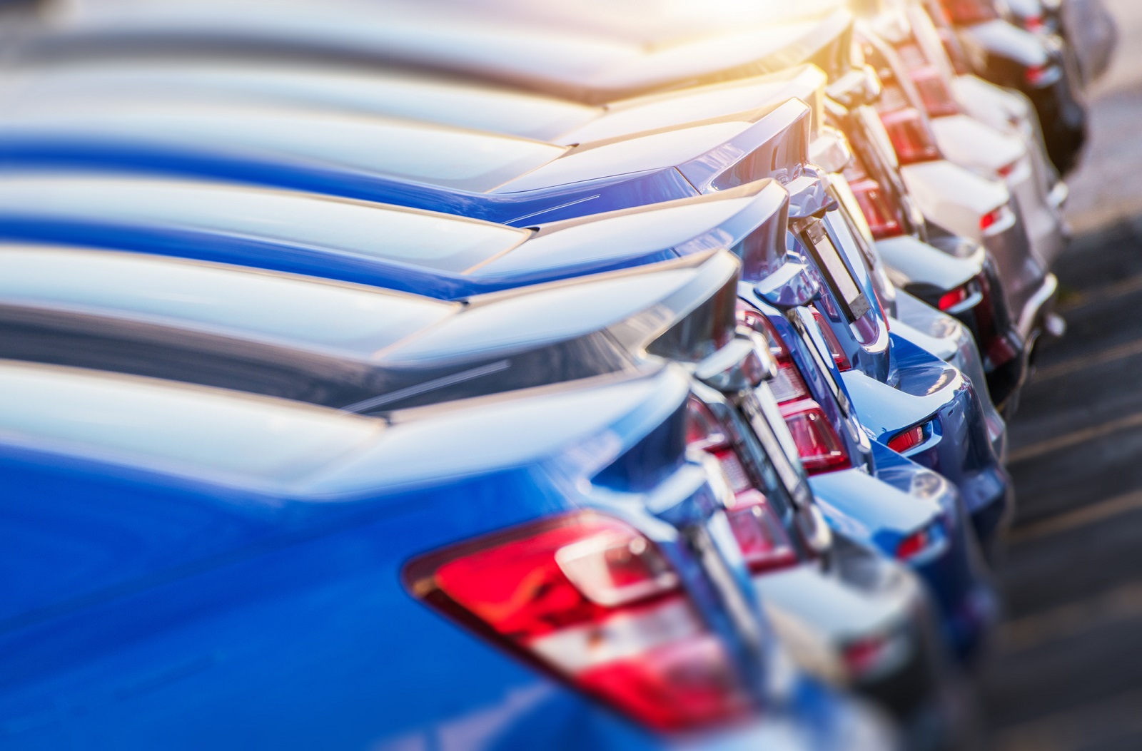 A row of new cars parked in close left rear view