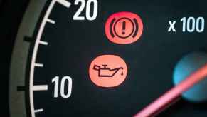 An oil can and exclamation point on car dashboard indicate low oil life