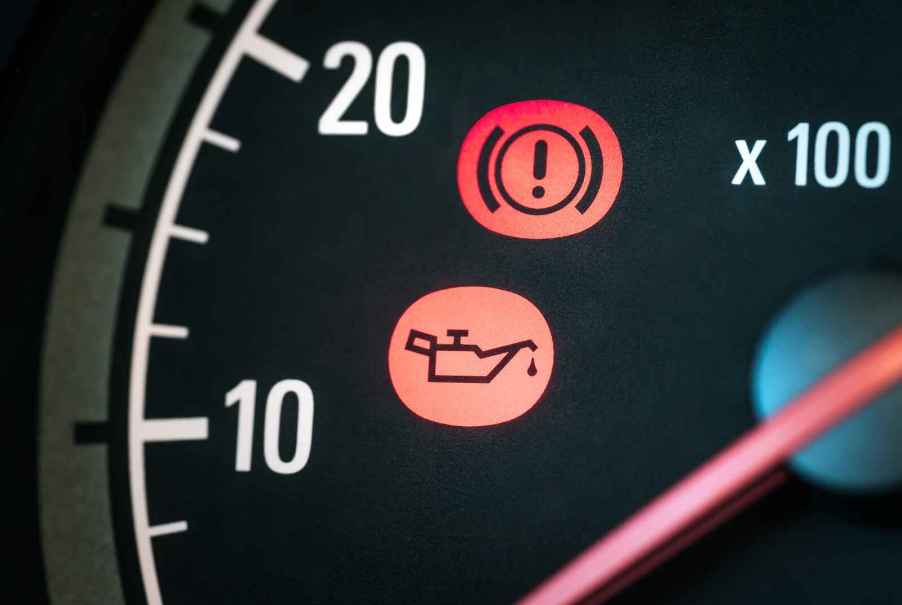 An oil can and exclamation point on car dashboard indicate low oil life