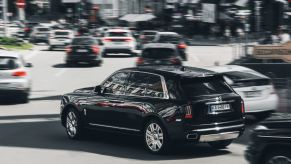 A Rolls Royce Cullinan being driven at speed