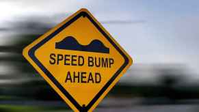 A speed bump warning sign in close view with blurred background
