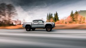 A Toyota Tacoma driving down a scenic highway, photographed in motion